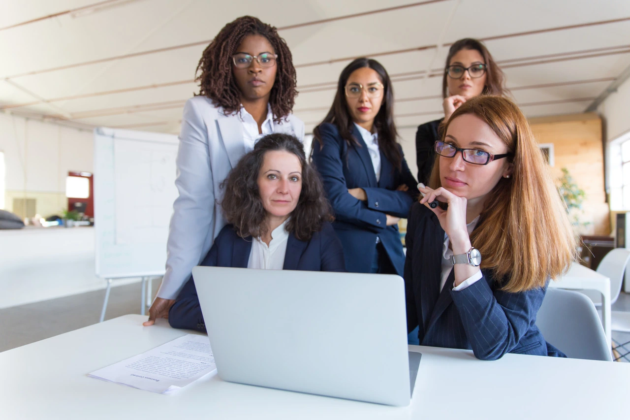 Mulheres em reunião de trabalho discutindo estratégias de liderança.