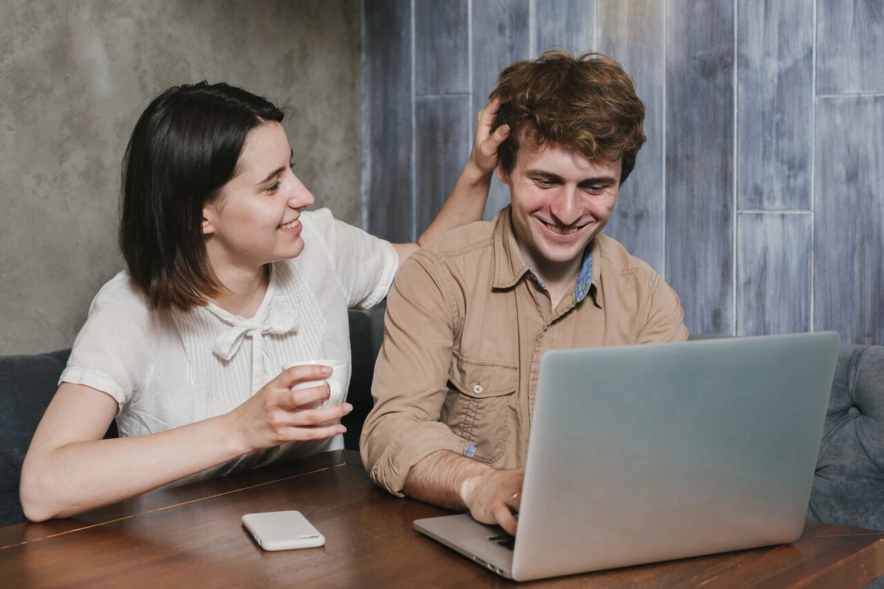 Colegas de trabalho sorrindo enquanto trabalham juntos em um escritório moderno.
